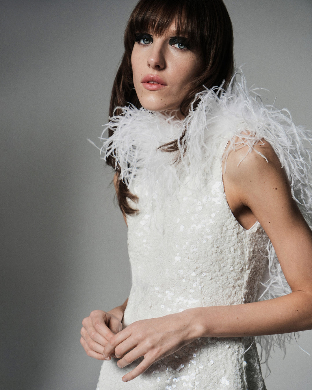 Платье мини из ткани, расшитой пайетками, декорированное перьями страуса